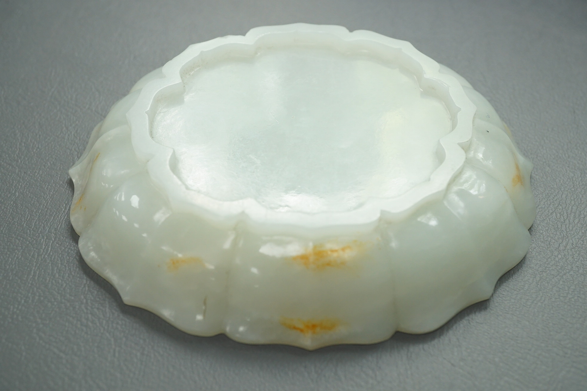 A Chinese white and russet jade petal lobed cup stand